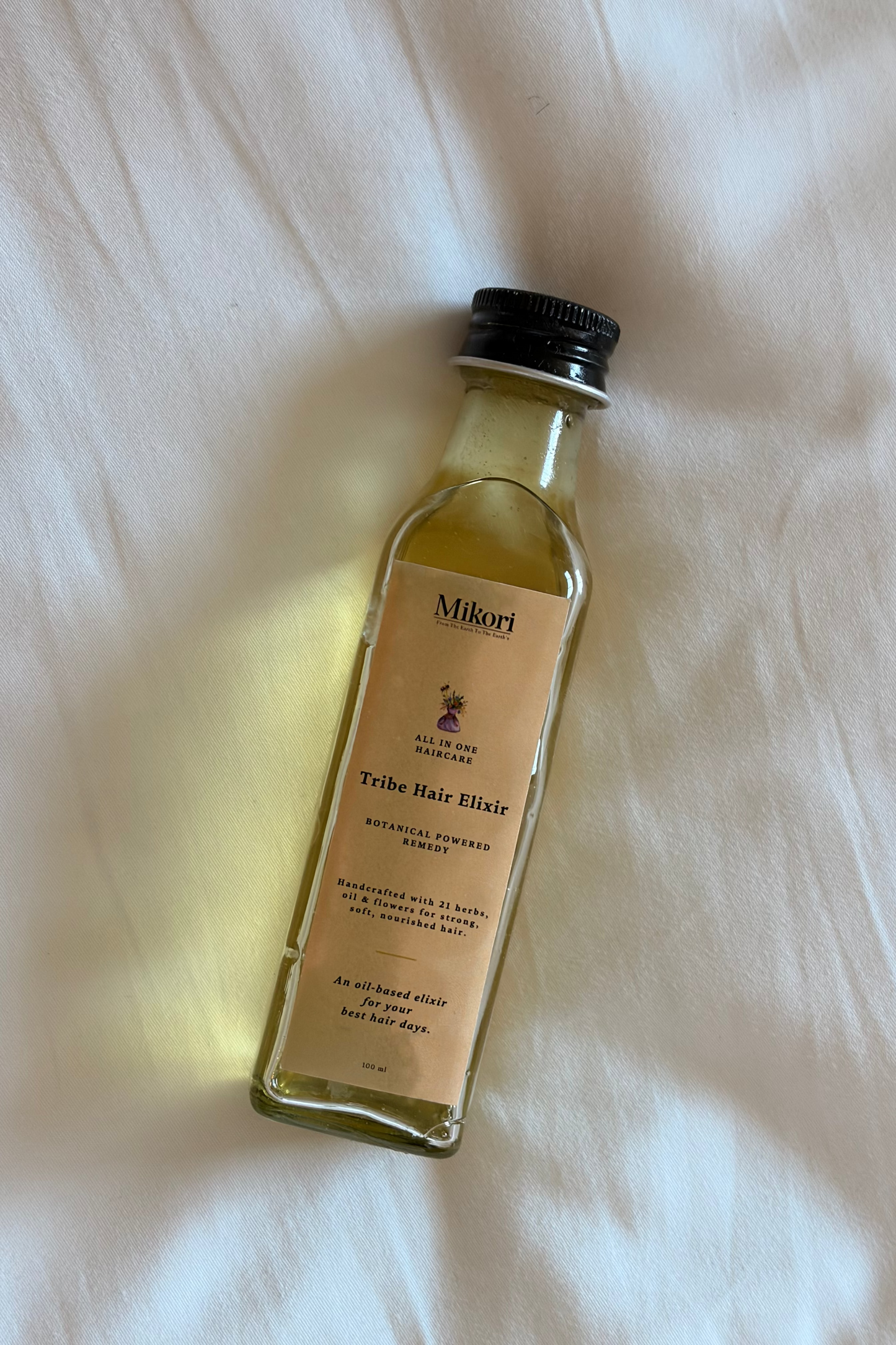Small bottle of Mikori Tribe Hair Elixir on a white surface