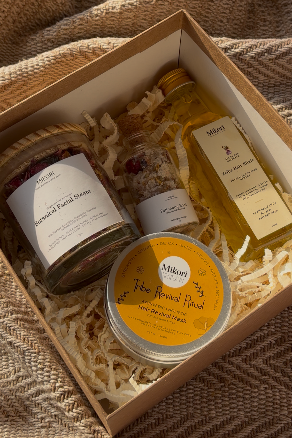 Gift box with skincare products on a textured fabric background